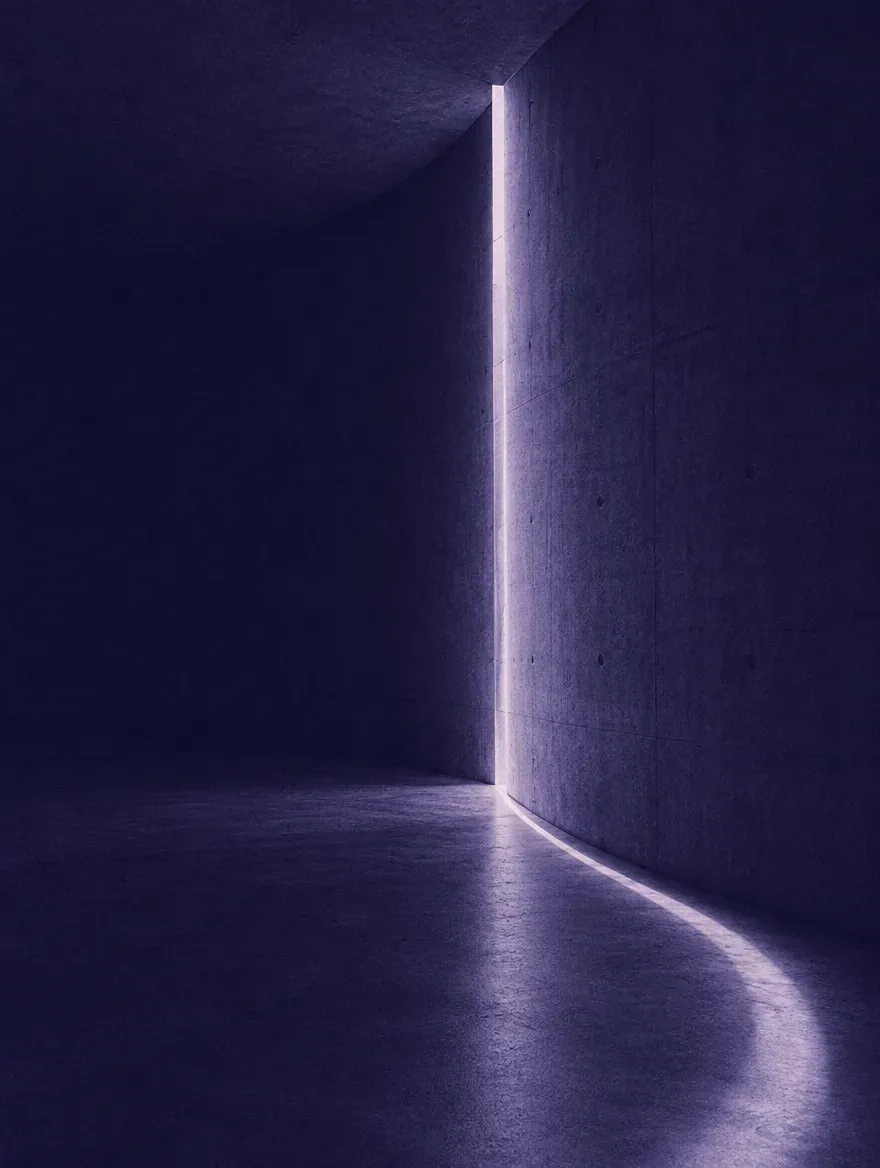 A slit of light cutting through a concrete corridor