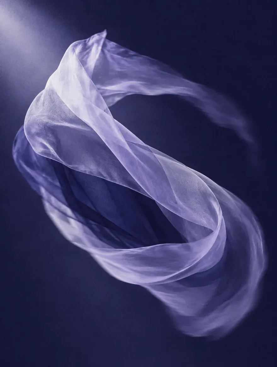 A ribbon of translucent silk twisting through the dark